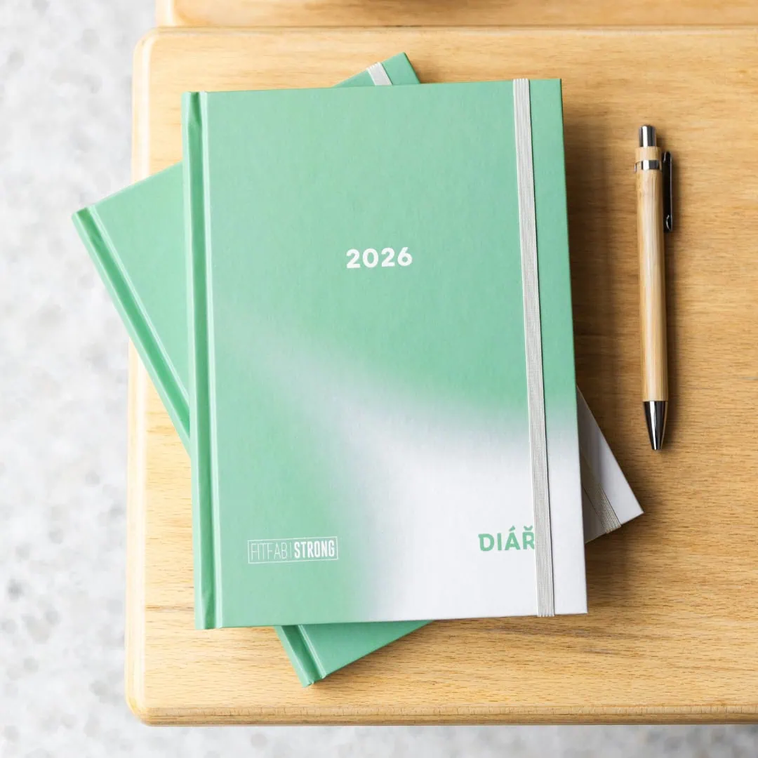 Tréninkový plán pro rok 2026 v zeleném diářu s nápisem "DIÁŘ" a propiskou vedle.